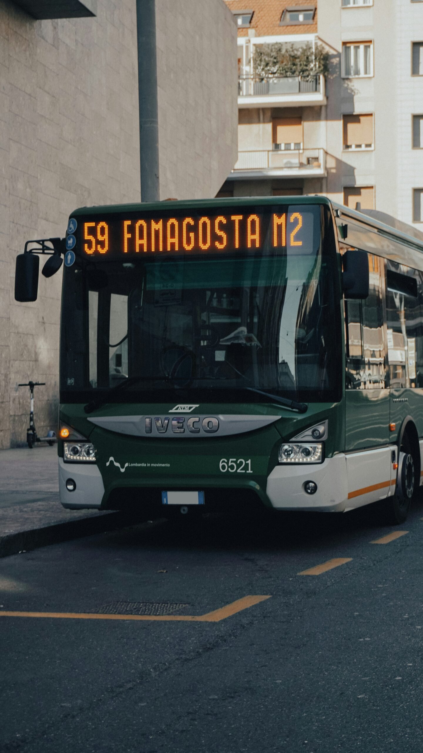 a green and white bus driving down a street